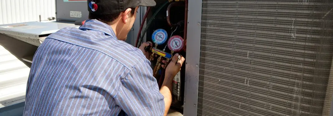 HVAC technician servicing a condenser unit in Searcy