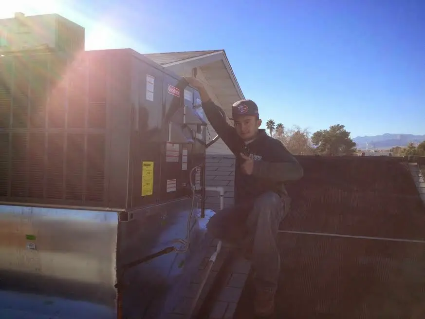 HVAC technician performing Heat Pump Repair on a rooftop unit in Searcy